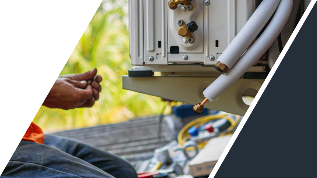 Technician repairing an outdoor air conditioning unit's refrigerant lines